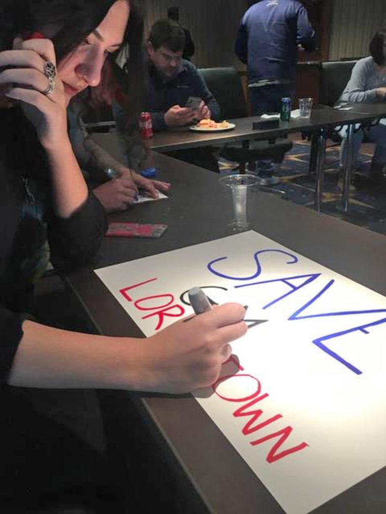 After losing her job at the GM plant in Lordstown, Ohio, Cheryl Jonesco had to leave her daughter, Marisa, with Jonesco's parents to take a job at a GM plant in Tennessee. Marisa is painting a sign for a November rally to save jobs at the plant.