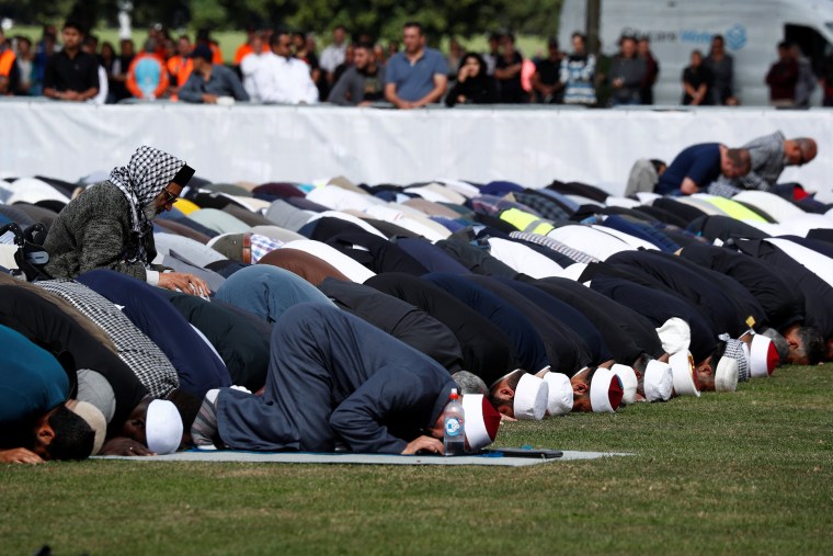 Image: People perform the Friday prayers at Hagley Park outside Al-Noor mosque in Christchurch