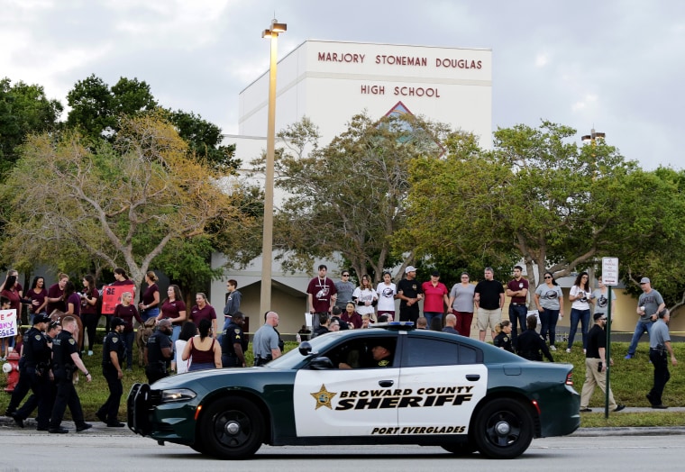 Image: A police car drives near Marjory Stoneman Douglas High School in Parkland, Florida, as students return to class for the first time after a shooting that left 17 dead on Feb. 28, 2018.