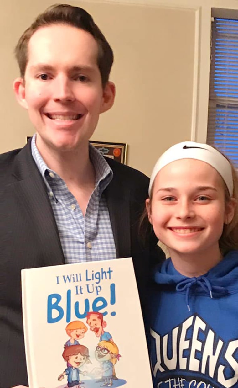 Kerry Magro shares his "I Will Light It Up Blue!" book with a child