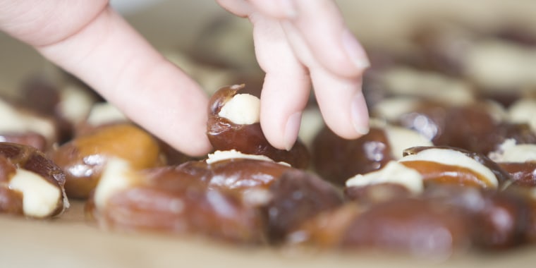 Close up of hand taking a marzipan stuffed date