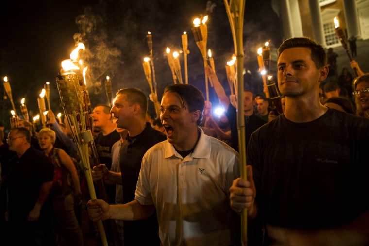 Image: Peter Cvjetanovic (C) along with Neo Nazis, Alt-Right, and White Supremacists encircle and chant at counter protesters at the base of a statue of Thomas Jefferson after marching through the University of Virginia campus with torches.