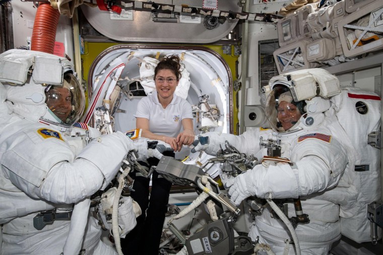 Image: NASA astronaut Christina Koch, center, assists fellow astronauts Nick Hague (left) and Anne McClain in their U.S. spacesuits shortly before they begin the first spacewalk of their careers