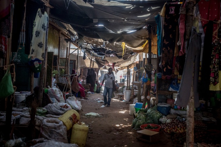Image: A man walks through a market in the Dadaab refugee camp.