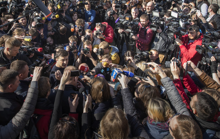 Image: Ukrainian comedian and presidential candidate Volodymyr Zelenskiy, left, is surrounded by journalists after voting at a polling station, during the presidential elections in Kiev