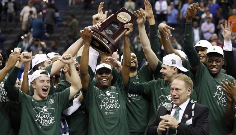 Image: Michigan State guard Cassius Winston holds up the NCAA men's East Regional trophy as he celebrates with his team after defeating Duke in a college basketball game in Washington