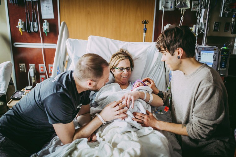 Image: Matthew Eledge, left, his mother Cecile Eledge, center, and Matthew's husband Elliot Dougherty, right, greet baby Uma
