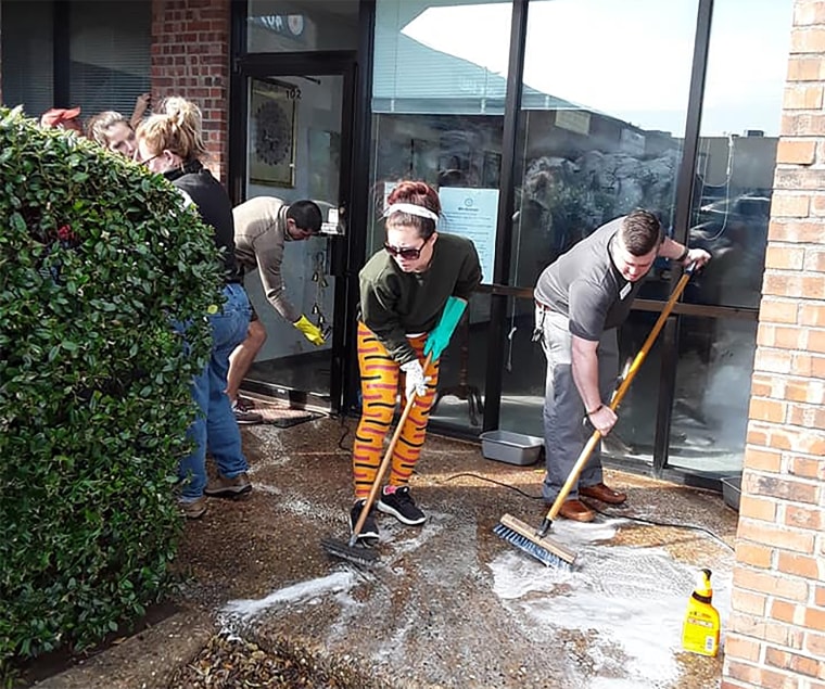 Volunteers clean up racist imagery at the Cleveland County Democratic Party building in Norman, Oklahoma on April 3, 2019.