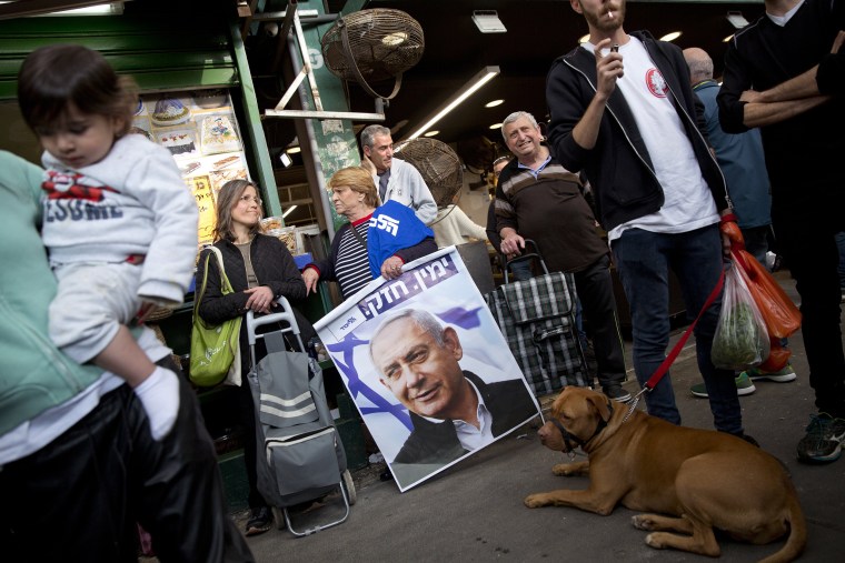 Image: An Israeli woman holds a poster depicting Israeli Prime Minister Benjamin Netanyahu