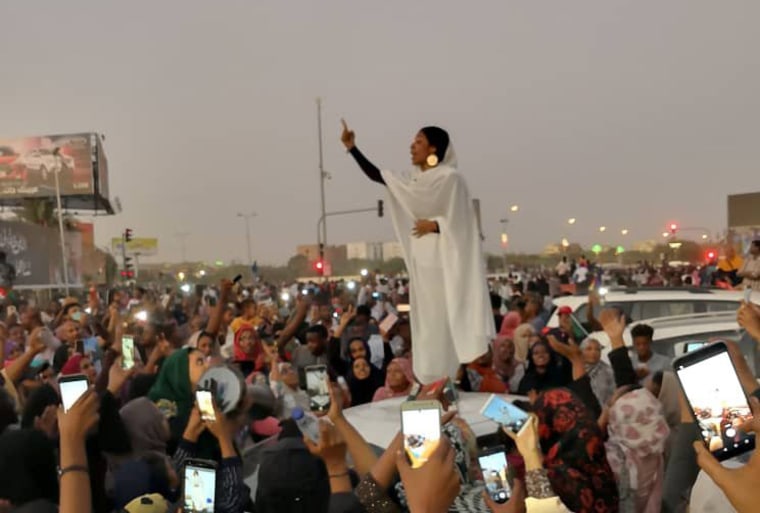 Image: A Sudanese woman gestures during a protest demanding Sudanese President Omar Al-Bashir to step down along a bridge in Khartoum
