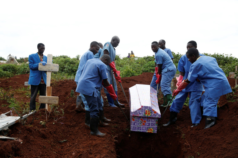 Image: Congolese Red Cross workers carry the coffin of Congolese woman Kahambu Tulirwaho who died of Ebola, during a burial service at a cemetery in Butembo