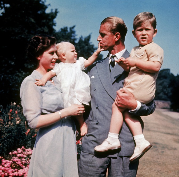 Former Princess Elizabeth holds her daughter, Princess Anne, who reaches out to her father, Prince Philip, as he holds Prince Charles in 1951.
