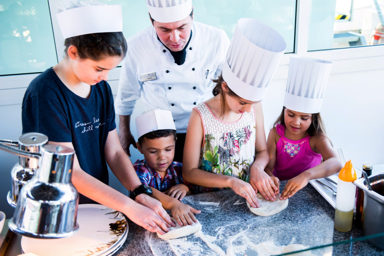 Children making pizza during an offshore excursion in Bologna, Italy.