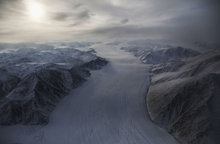 A section of glacier flows between ridges on Ellesmere Island, Canada.