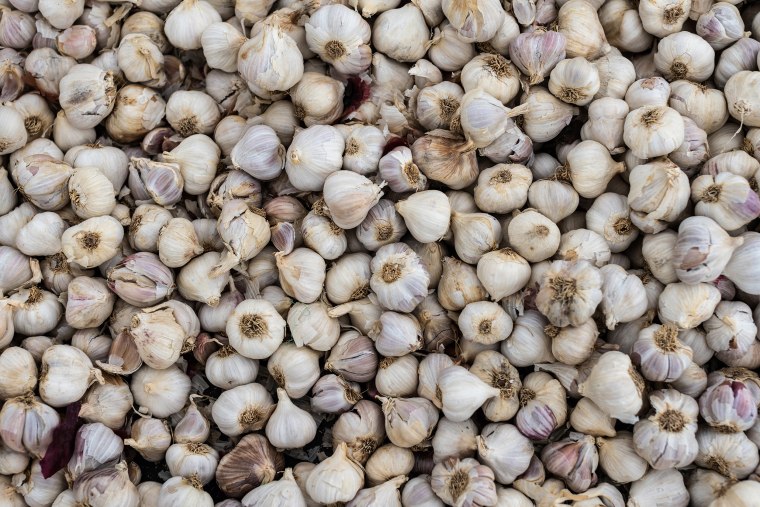 Image: Garlic is heaped on a mat beside a roadside stall in Kiawara, Kenya