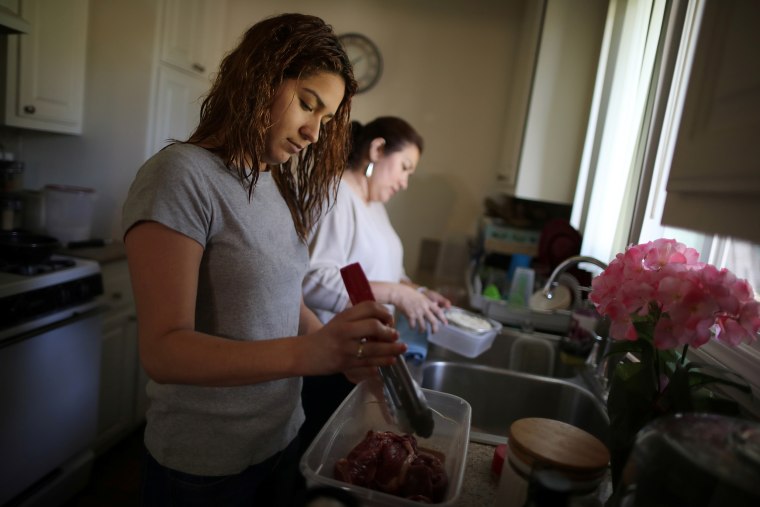 Salvadoran immigrant Isabel Barrera, 47, who has lived in the U.S. for 20 years and has Temporary Protected Status (TPS), cooks lunch with her daughter Andrea Barrera, 22, (L) who has Central American Minors Program (CAM) legal status, at their home i
