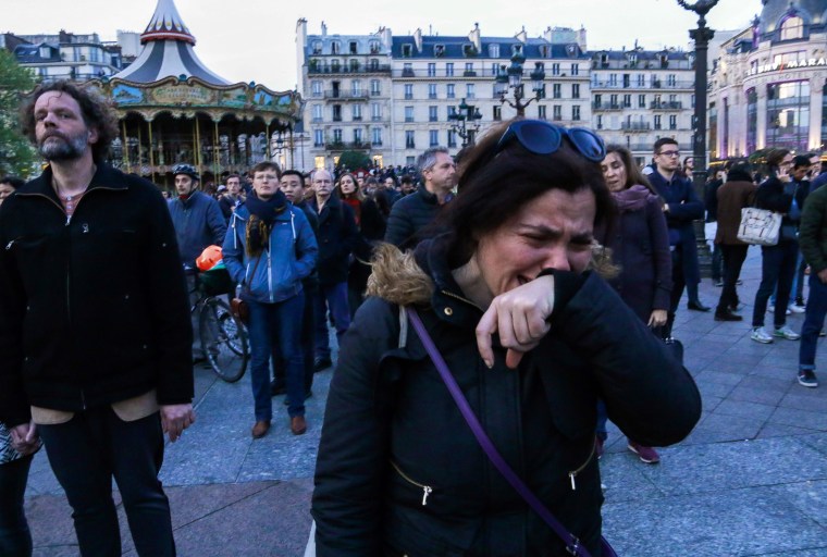 Image: A woman cries near Notre Dame Cathedral in Paris