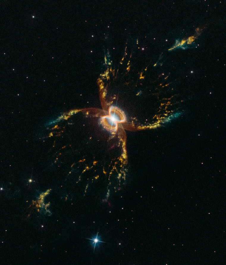 In celebration of the 29th anniversary of the launch of NASA's Hubble Space Telescope, astronomers captured this festive, colorful look at the tentacled Southern Crab Nebula.
The nebula, officially known as Hen 2-104, is located several thousand light-years from Earth in the southern hemisphere constellation of Centaurus. It appears to have two nested hourglass-shaped structures that were sculpted by a whirling pair of stars in a binary system. The duo consists of an aging red giant star and a burned-out star, a white dwarf. The red giant is shedding its outer layers. Some of this ejected material is attracted by the gravity of the companion white dwarf.