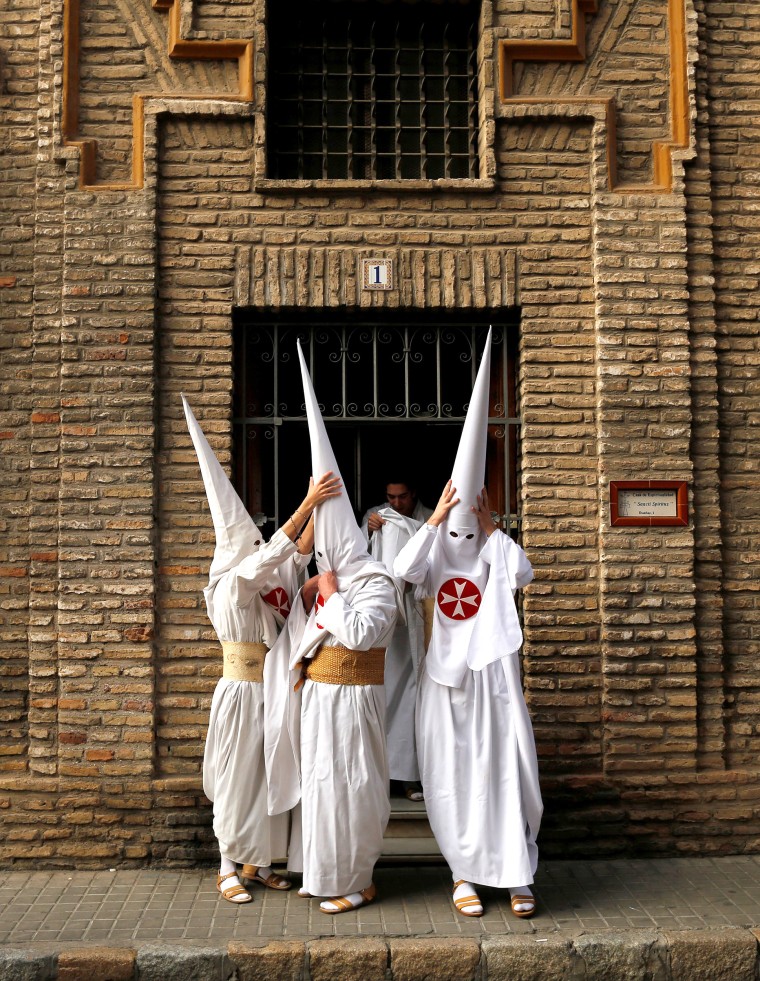 Image: Penitents of La Amargura brotherhood make their way to a church during Holy Week in the Andalusian capital of Seville