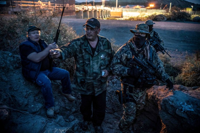 Image: Members of the United Constitutional Patriots share cigarettes while on patrol in Sunland Park, New Mexico, on March 20, 2019.