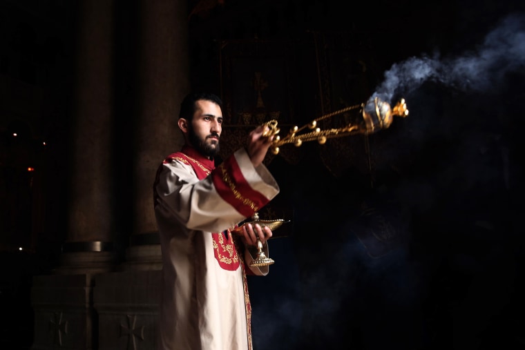 Image: A priest waves a censer during the Palm Sunday procession at the Church of the Holy Sepulchre, believed to be the traditional site of Jesus's resurrection, in Jerusalem on April 21.