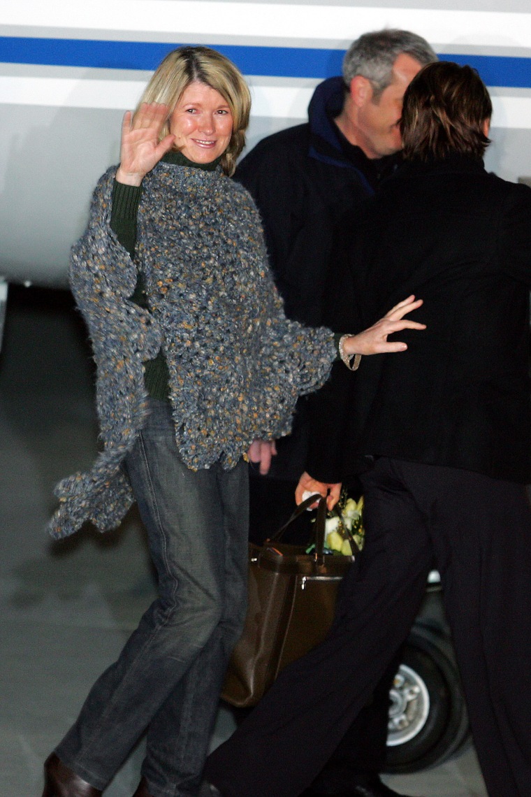 Martha Stewart waves cheerfully as she boards a plane