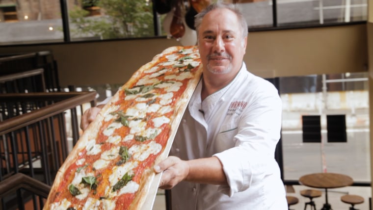 Fornino chef Michael Ayoub carries his delicious pizza, which is 6 feet long, to a table of hungry diners. 