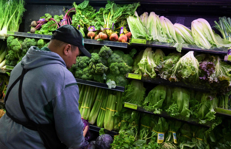 A produce worker stocks shelves near romaine lettuce at a Whole Foods supermarket in Washington on Nov. 20, 2018.