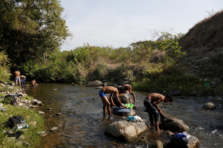 Image: Central American migrants traveling in a caravan wash clothes and take baths in a river near Mapastepec in Mexico on April 21, 2019.