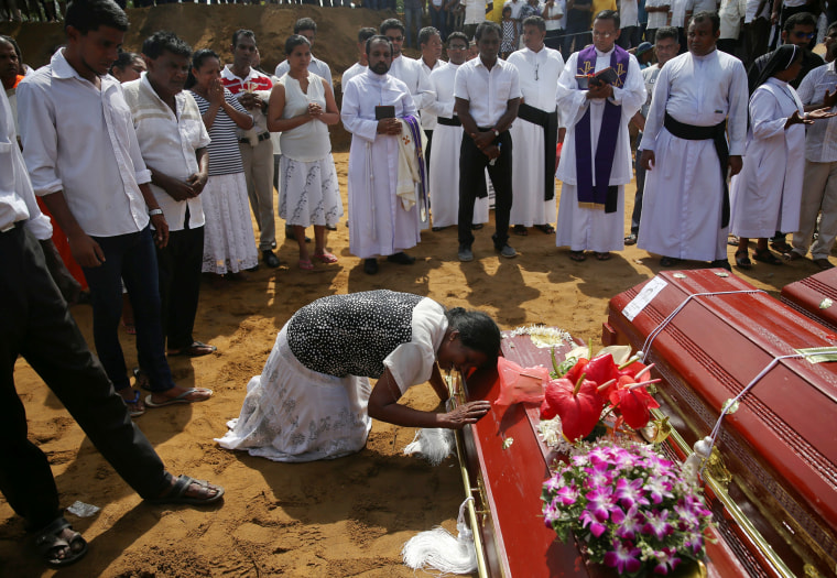 Image: A woman reacts next to a coffin during a mass burial of victims at a cemetery near St. Sebastian Church in Negombo