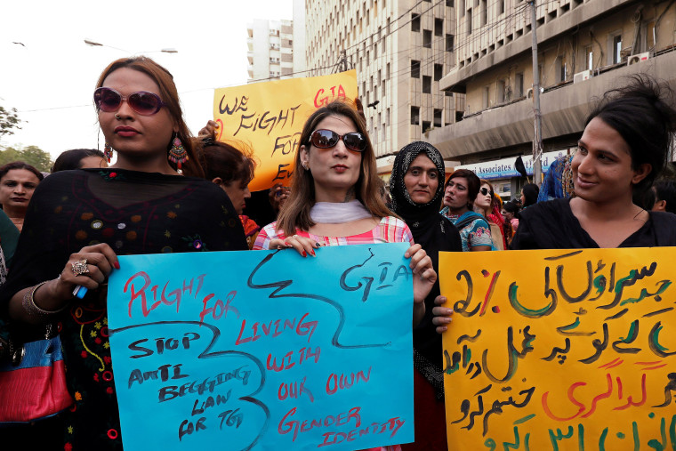 Image: Members of the transgender community hold signs against the anti-begging law for the transgender community, during a protest demanding jobs in Karachi