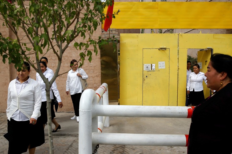 Ethnic Uighur women leave a centre where political education lessons are held in Kashgar