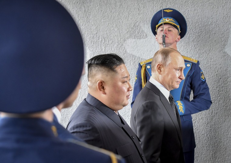 Image: Russian President Vladimir Putin and North Korea's leader Kim Jong Un, center, pass honor guards officers during their meeting in Vladivostok