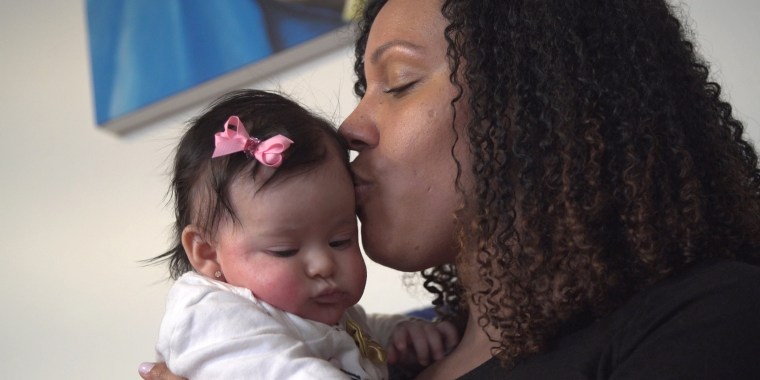 Theanne Griffith kisses her youngest daughter, Lila. Griffith began experiencing pelvic-floor problems after Lila's birth.