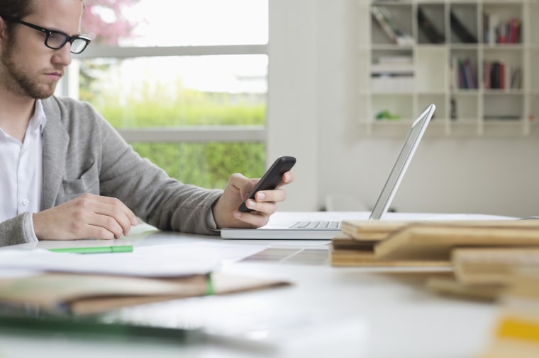 Interior designer using a mobile phone in the office