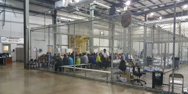 Image: People who've been taken into custody sit in one of the cages at a facility in McAllen, Texas