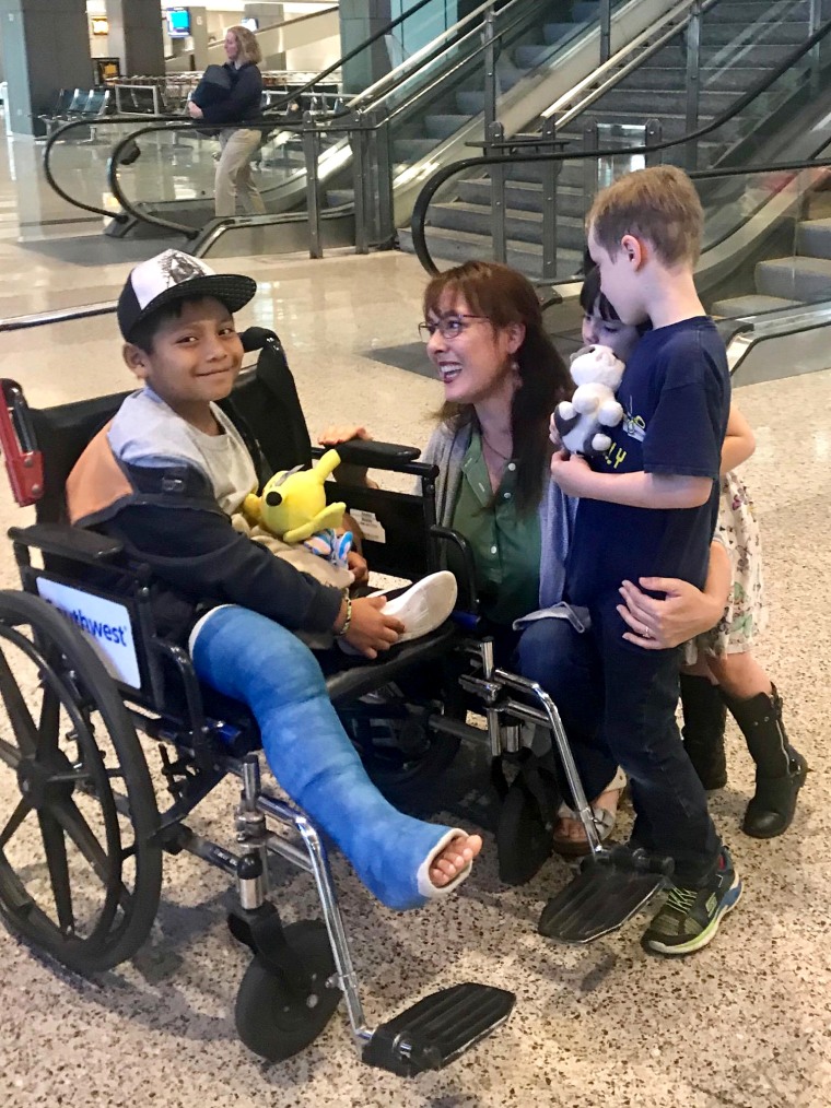 Holly Sewell, 41, and her two children Desmond, 6, and Winifred, 5, welcomes Byron Xol, 8, at the Austin Bergstrom International Airport after he was released from a federal shelter for immigrant children, to live with the Sewell family.