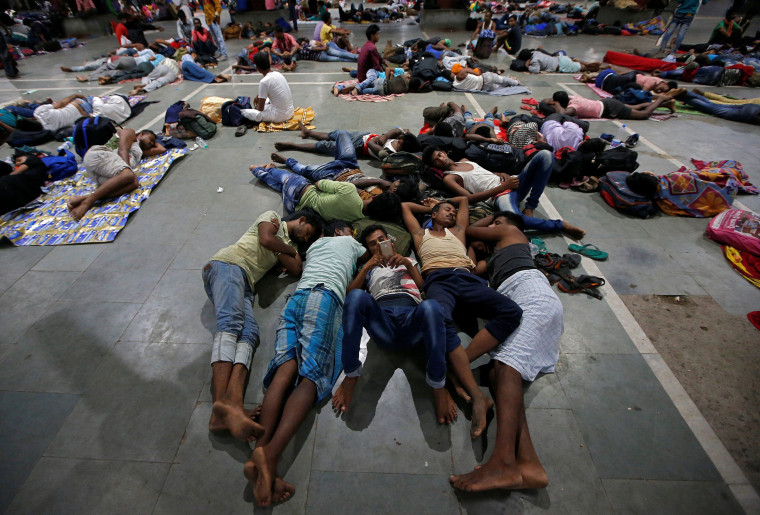 Image: Stranded passengers rest inside a railway station after trains were cancelled ahead of Cyclone Fani