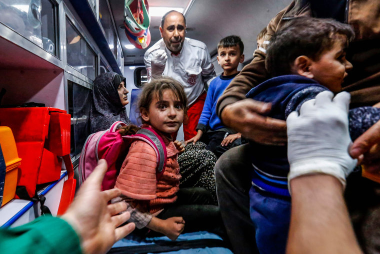 Image: A Palestinian family waits for medical help inside an ambulance in the Gaza Strip