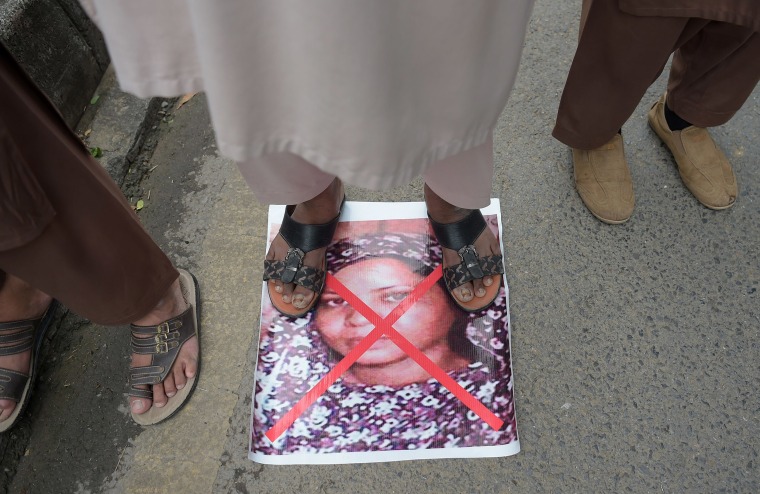 A protester stands on an image of Aasia Bibi in November.