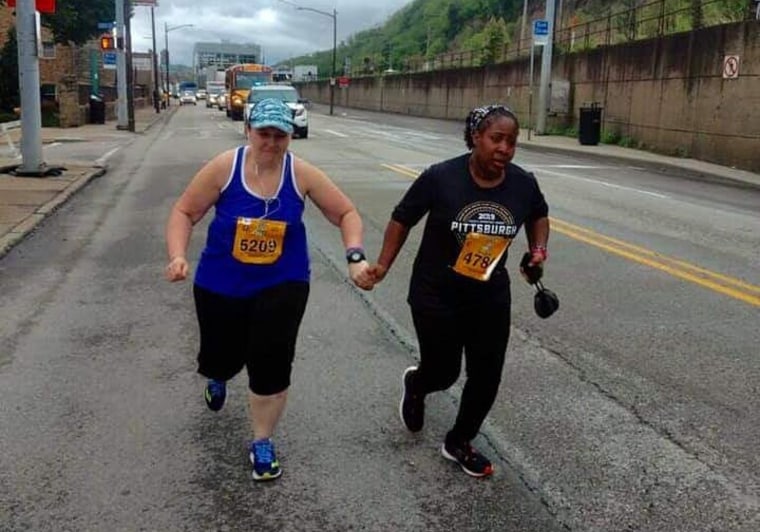 Image: Runners hold hands at the 25 mile marker during the Pittsburgh Marathon.