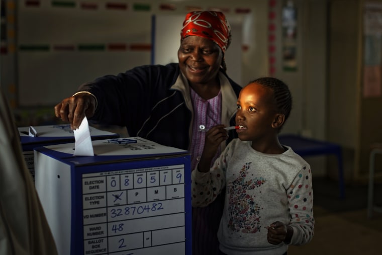 Image: A young girl accompanies a relative as she casts her vote the South African presidential election in Johannesburg on May 8, 2019.