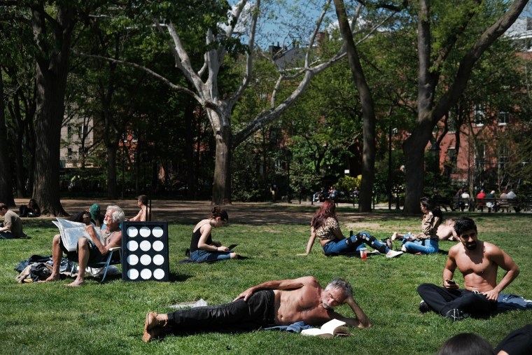 Image: Sunbathers relax in Washington Square Park in New York on May 8, 2019.