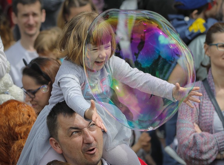 Image: A child reaches for a bubble at the Global Bubble Parade in Bucharest, Romania, on May 5, 2019. Soap bubble fans enjoy the international event held in 125 cities across 60 countries.