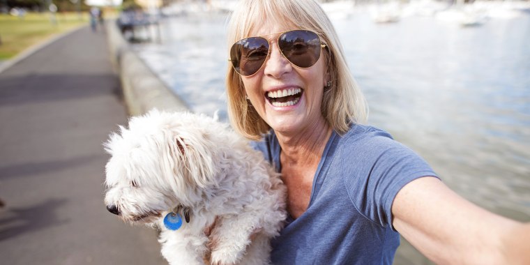 Mature woman taking selfie with dog
