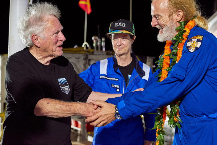 Don Walsh, left, and Victor Vescovo shake hands aboard the ship, DSSV Pressure Drop.