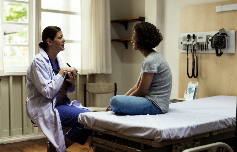 Image: A doctor meets with a female patient