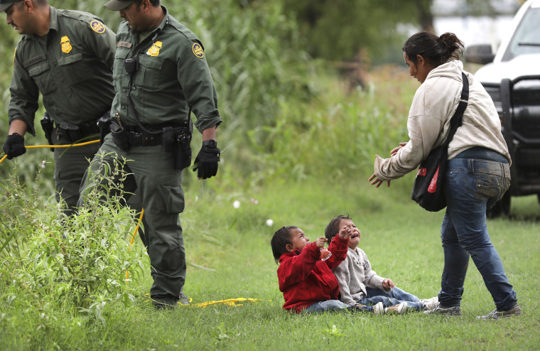 A mother from Honduras goes to her two children on the banks of the Rio Grande River on May 10. 
