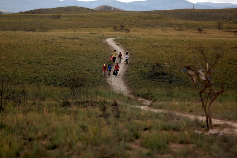 Image: Venezuelans walk along a trail into Brazil near the city of Pacaraima on April 13, 2019.