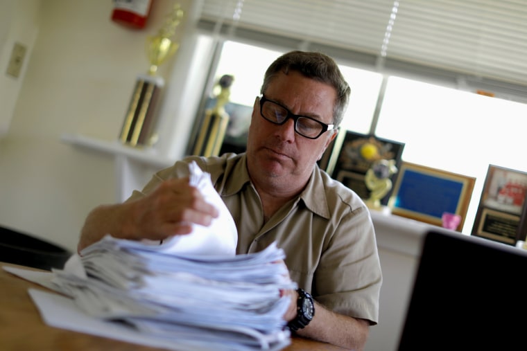 Image: Scott Rosmarin sorts campers' immunization forms at the camp office in Monroe, New York, on May 20, 2019.